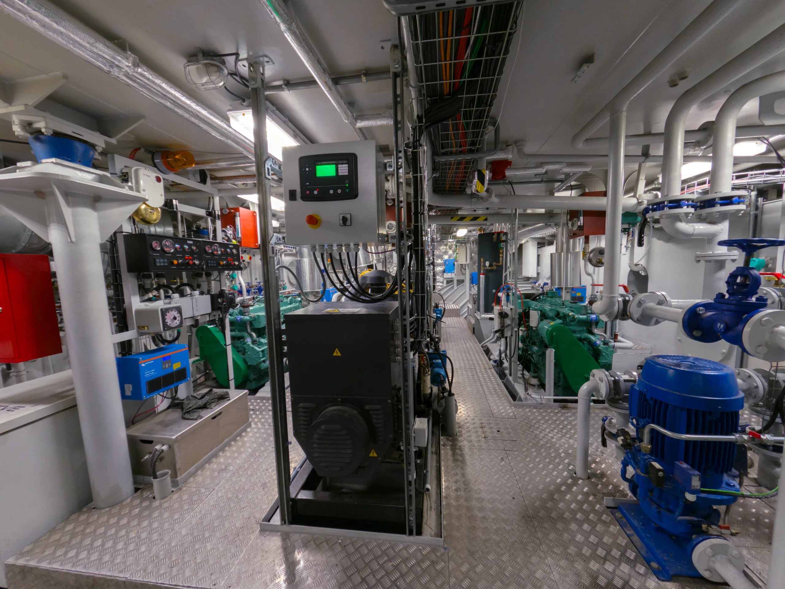 Modern ship engine room with engines, pumps and control panels